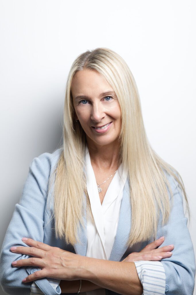 Half body portrait of a blonde woman smiling at the camera taken by a professional business photographer in kent