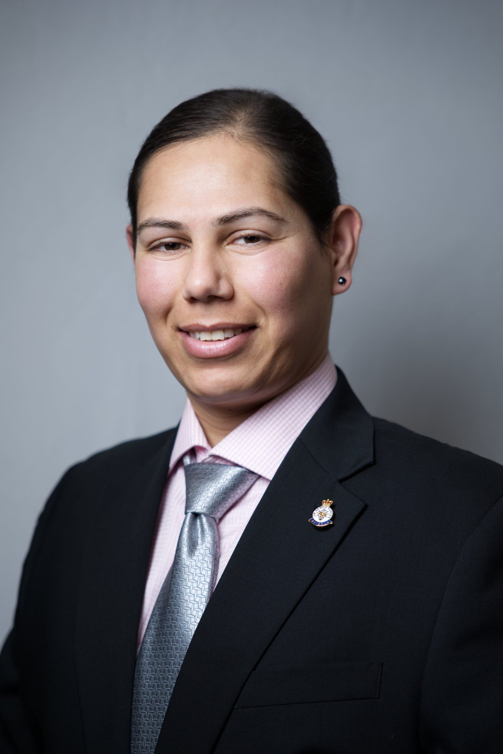 Medway headshot of a woman wearing a suit against a grey background
