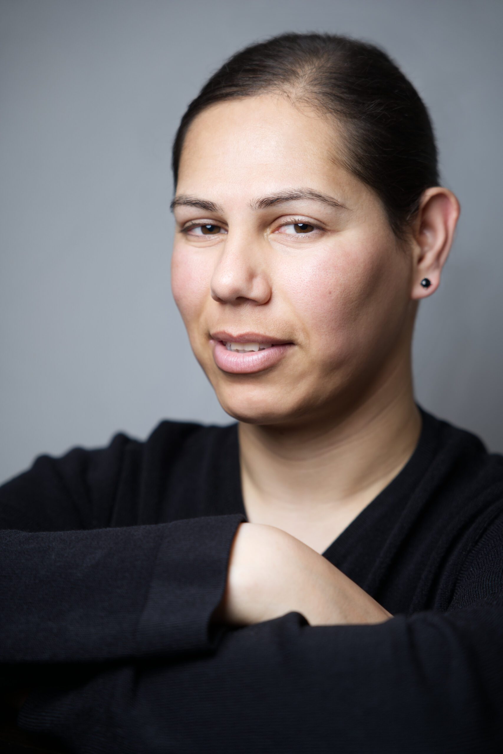 Close up portrait of a woman sitting on a chair, leaning against the backrest, taken by a headshot photographer in Medway