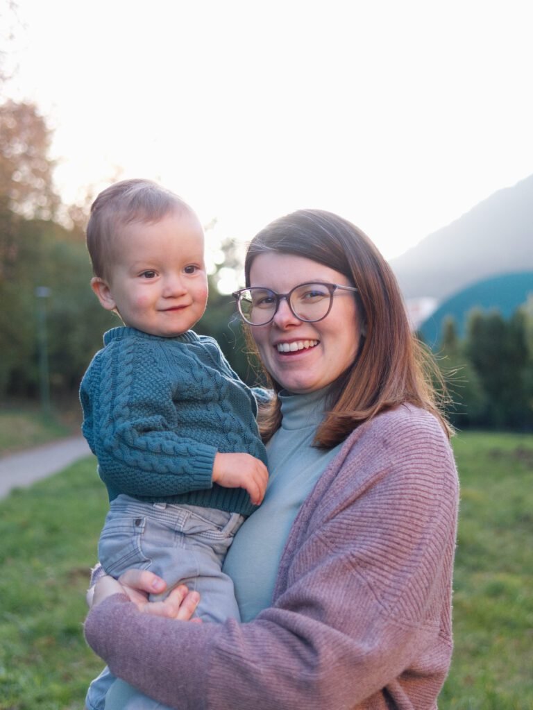 Family photographer Kent Mum holding a toddler and smiling at the camera during a family photoshoot by a Kent photographer